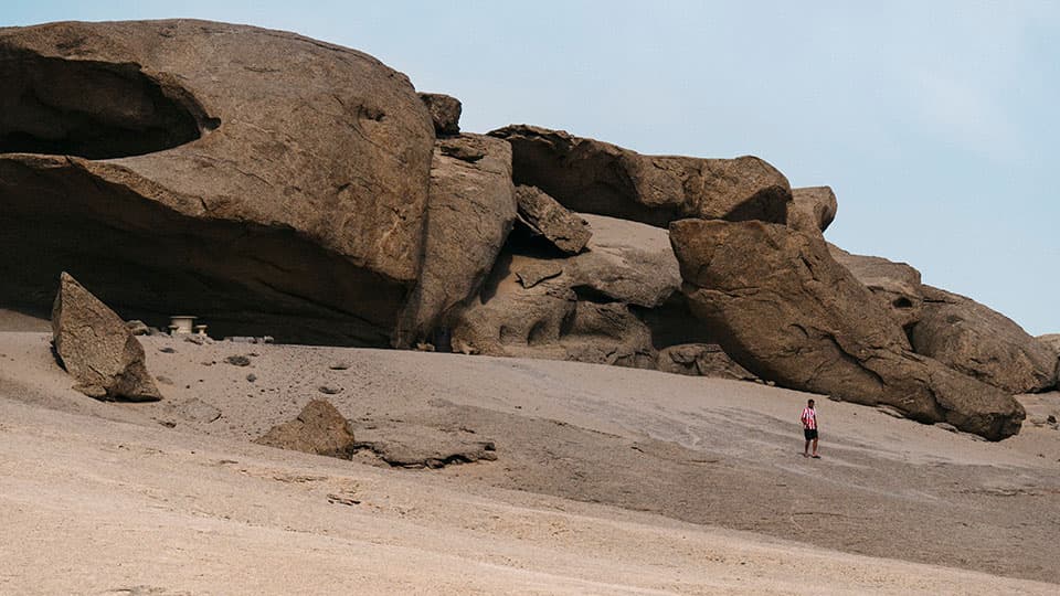 a person standing in landscape with large rock formations in the background